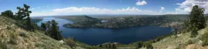Panorama of deep blue Fremont Lake between sagebrush hills and pines under a summer sky